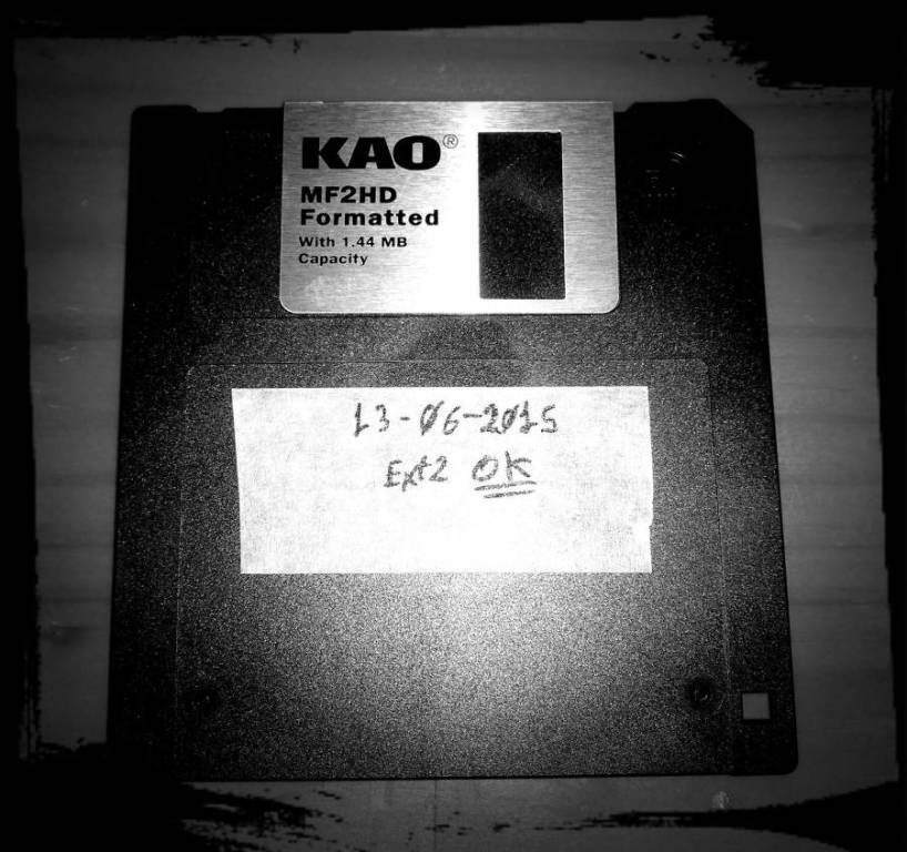Disquete floppy en branco e negro con un cadro irregular negro ao redor da imaxe.